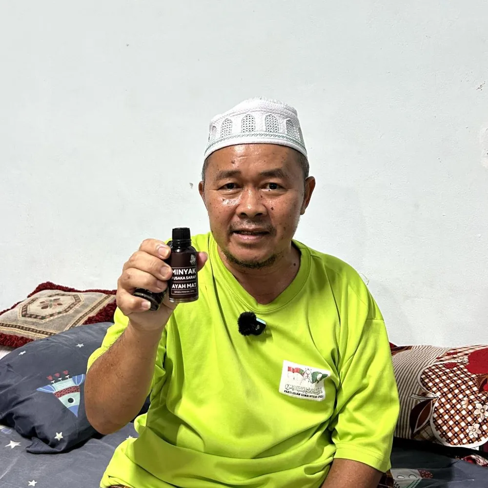 Pelanggan menunjukkan botol Minyak Urut Pusaka Ayah Mat