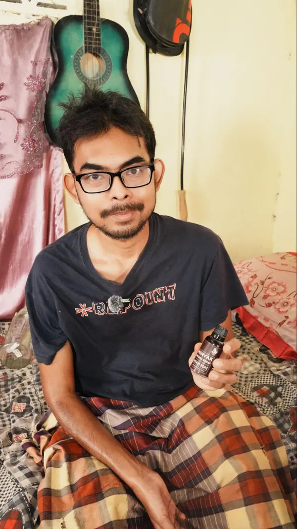 Pelanggan memegang botol Minyak Urut Pusaka Ayah Mat